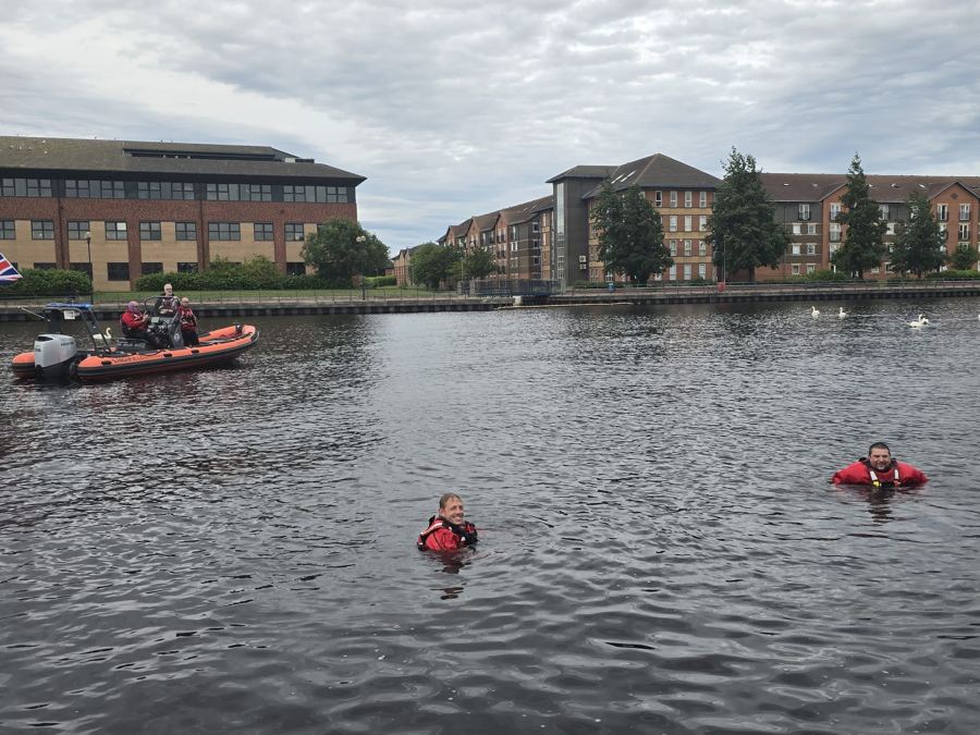 Open water swimmers with a Tees River Rescue safety boat standing by